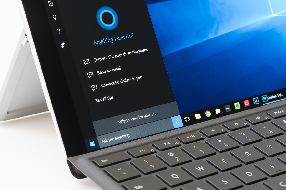 Colț ecran laptop Windows 10. Tastatura e neagră, ecranul e albastru cu negru, fundalul alb