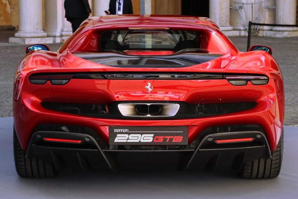 Spate mașină Ferrari 296 GTB roșie, parcată la o prezentare de mașini