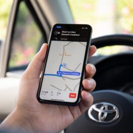 Aplicație de navigare pe telefon, care e ținut în mânî de un șofer aflat în mașină. Aplicațiile de navigare precum Waze și Google nu prezic rute perfecte de fiecare dată
