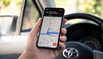 Aplicație de navigare pe telefon, care e ținut în mânî de un șofer aflat în mașină. Aplicațiile de navigare precum Waze și Google nu prezic rute perfecte de fiecare dată