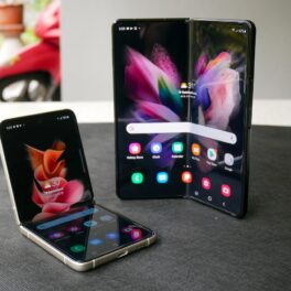 Telefoanele Galaxy Z Fold 3 și Z Flip 3 pe un birou alb, pe o porțiune gri închis. Ambele sunt deschise. Samsung a testat cât de rezistent e Galaxy Z Fold 3