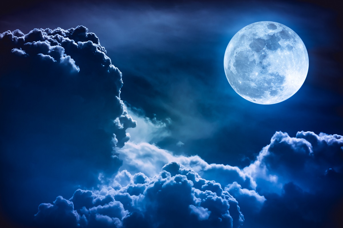 Imagine cu Luna pe cer, în tonuri albastre. Luna e în colțul drept, deasupra norilor. Experții cred că Luna se va ”clătina” în 2030