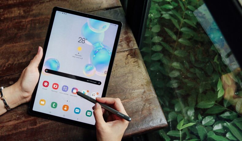 Tableta Samsung Galaxy Tab S6, folosită de un utilizator pe un birou din lemn, cu o ferigă în colț. Până la începutul anului 2022, va fi lansată Samsung Galaxy Tab S8 Ultra, potrivit zvonurilor