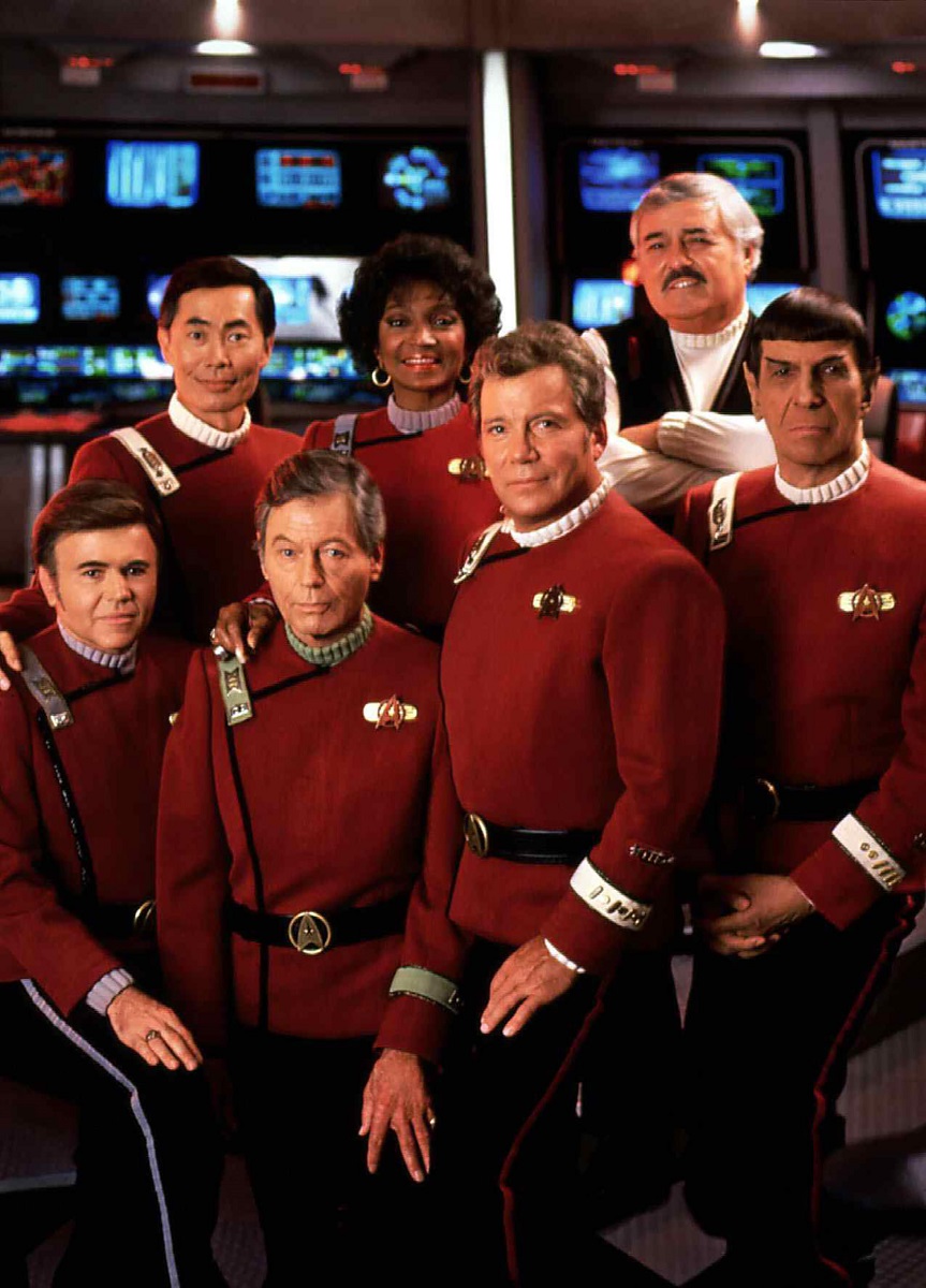 Imagine cu William Shatner în Star Trek, alături de colegii de platou. În imagine apar Walter Koenig, George Takei, DeForest Kelly, Nichelle Nichols, James Doohan și Leonard Nimoy, îmbrăcați în uniforme roșii