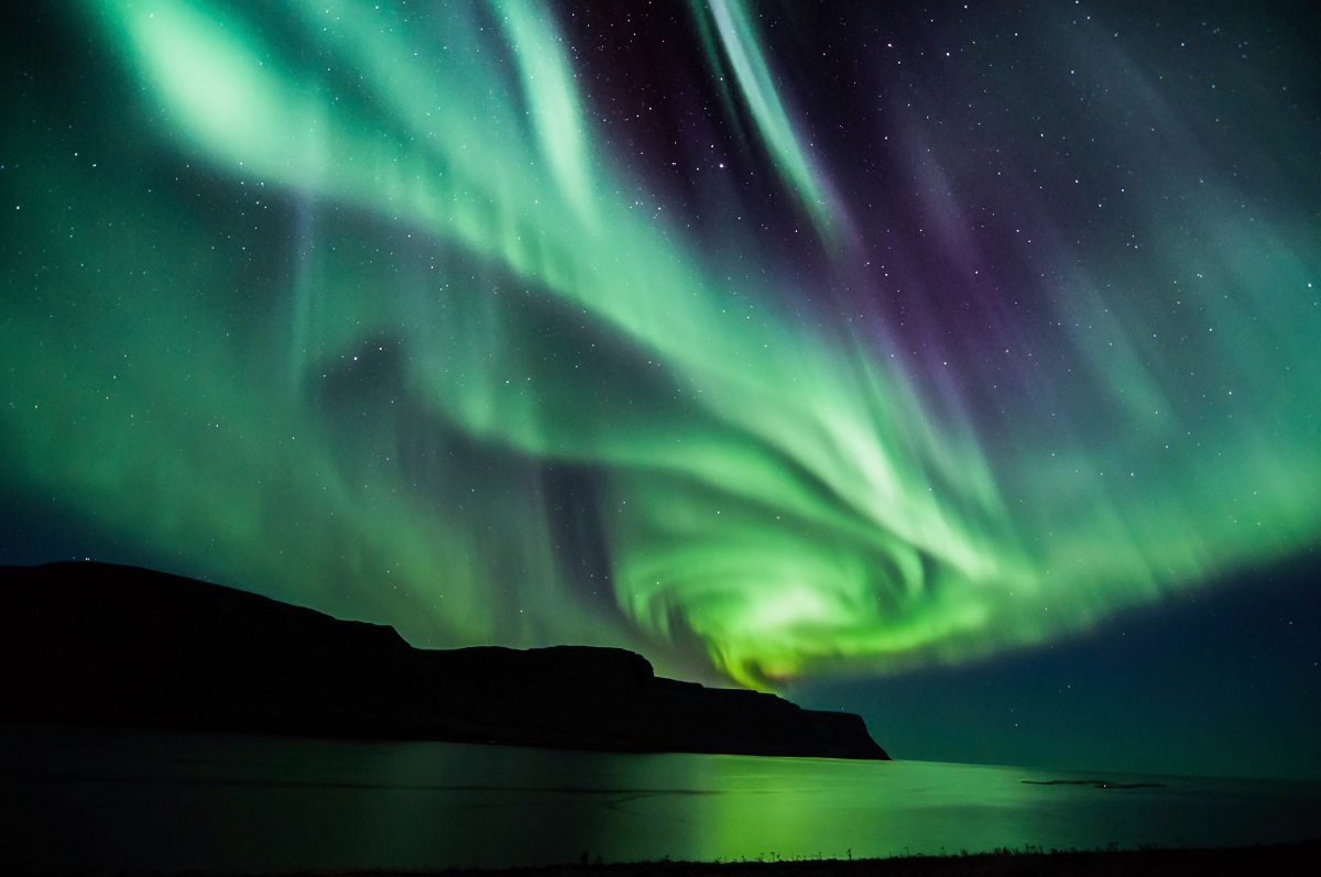 Aurora Boreală în nuanțe de albastru, verde și mov, în spirală, în Islanda