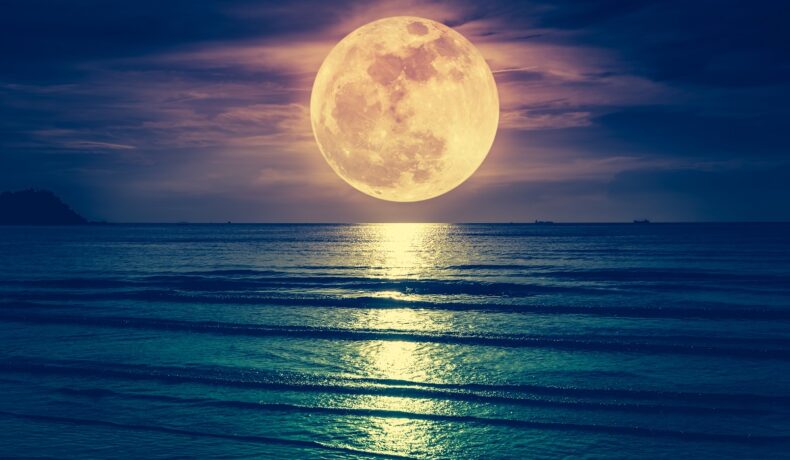 Luna deasupra mării, noaptea. Apa e albastră, Luna e galbenă și se reflectă în suprafață
