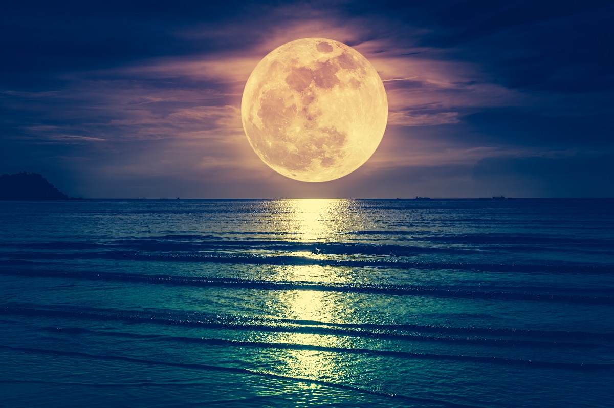 Luna deasupra mării, noaptea. Apa e albastră, Luna e galbenă și se reflectă în suprafață