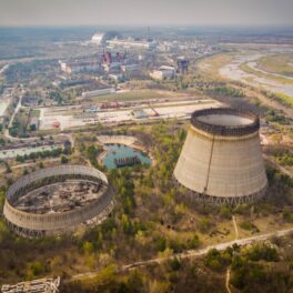 Reactorul nuclear de la Cernobîl, fotografiat din aer În stânga e un râu, reactorul e gri, înconjurat de natură