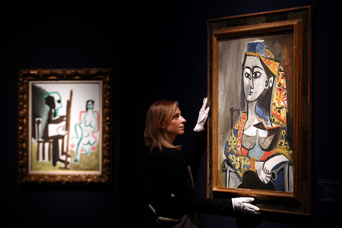 Tabloul Femme au costume turc dans un fauteuil, pictat de Pablo Picasso. A fost expus în anul 2014 la Casa de licitații Christies, fundal negru, rama aurie