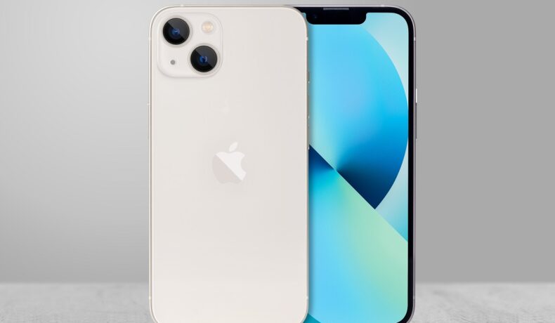 Iphone 13, pe culoare albă, cu ecran albastru șși fundal gri. Ecranul iPhone 13 a fost criticat