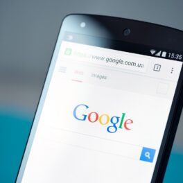 Telefon Android cu Google Chrome deschis pe ecran. Gri și albastru pe fundal. Google a eliminat o vulnerabilitate Android recent
