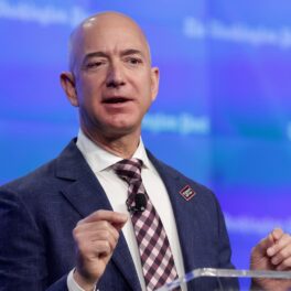 Jeff Bezos, la inaugurarea noii locații a Washington Post, publicaia pe care o deține, în 2016. Poartă un costum albastru, cămașî albă și cravată, cu fundal albastru. Jeff Bezos a donat recent 100 de milioane de dolari pentru Obama Foundation
