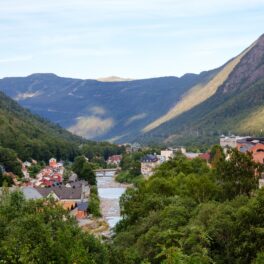 Orașul Rjukan nu avea soare 6 luni din an, dar o nouă tehnologie aduce razele în piața așezării. Imagine panoramică a orașului, vara, înconjurat de munți. Multă verdeață și acoperișuri