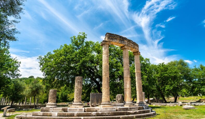 Philippeion din Altis din orașul Olympia, Grecia, Memorial ionic circular, cu copaci în spate, cerul albastru în partea de sus. Orașul antic Olympia va fi recreat digital cu ajutorul companiei Microsoft