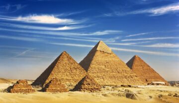 Celebrele piramide din Giza, construite în deșert, cu cerul albastru pe fundal. Ultima piramidă regală construită în Rgipt avea mormântul construit în spatele ei