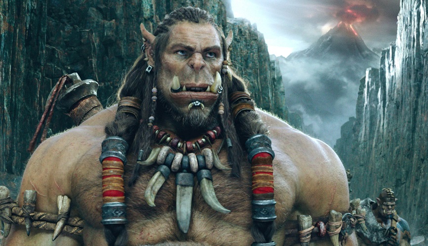 Imagine din filmul Warcraft, lansat în anul 2016. Apare un orc, cu munți pe fundal, care are coliere colorate