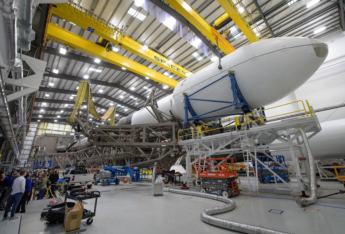 Racheta Falcon 9, din partea Space X, care participă în misiunea DART a NASA. Racheta e într-un hambar, cu bârne galbene, racheta e albă