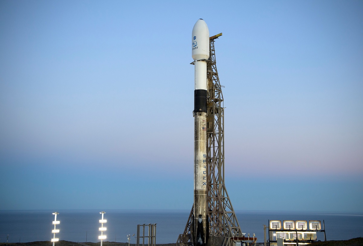 Racheta SpaceX Falcon 9 cu vehiculul spațial DART, pe 23 noiembrie 2021, înainte să decoleze în spațiu. Racheta e albă, pe fundal se vede cerul albastru