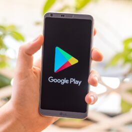 Telefon cu ecran negru, cu logo-ul Google Play, în mâna unui utilizator. Cele mai bune aplicații Android din 2021 au fost dezvăluite de Google