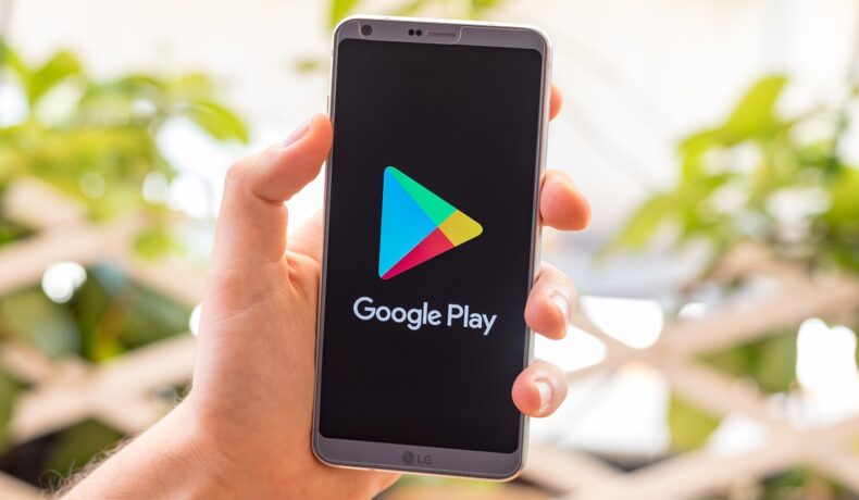 Telefon cu ecran negru, cu logo-ul Google Play, în mâna unui utilizator. Cele mai bune aplicații Android din 2021 au fost dezvăluite de Google