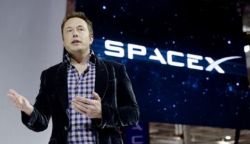 Elon Musk, pe scenă, la un eveniment SpaceX, când a dezvăluit nava The Dragon V2, în 2014. Logo-ul SpaceX se află în spatele lui, el e îmbrăcat în costum negru. Elon Musk a fost criticat de cetățenii chinezi din cauza proiectului Starlink