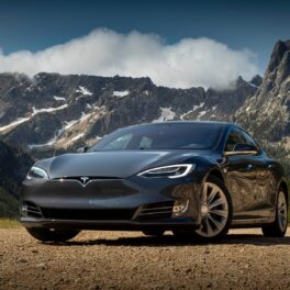 Mașină Tesla Model 3, pe gri, fotografiată în fața unui munte din Canada. Proprietarul unei mașini Tesla a decis s-o dinamiteze
