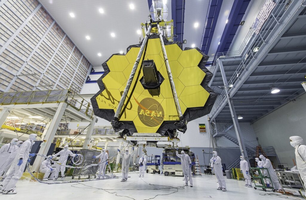 Telescopul James Webb înainte de lansare, într-un hambar, cu oglinzile galbene. Experții NASA estimează că Telescopul James Webb are combustibil pentru mai mult de 10 ani
