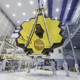 Telescopul James Webb înainte de lansare, într-un hambar, cu oglinzile galbene. Experții NASA estimează că Telescopul James Webb are combustibil pentru mai mult de 10 ani
