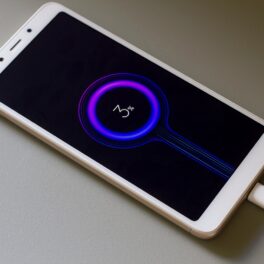 Telefon Xiaomi Redmi la încărcat, cu o carcasă albă, pe un fundal alb. Pe ecranul negru apare simbolul de încărcare. Xiaomi a dezvăluit o tehnologie nouă de baterie