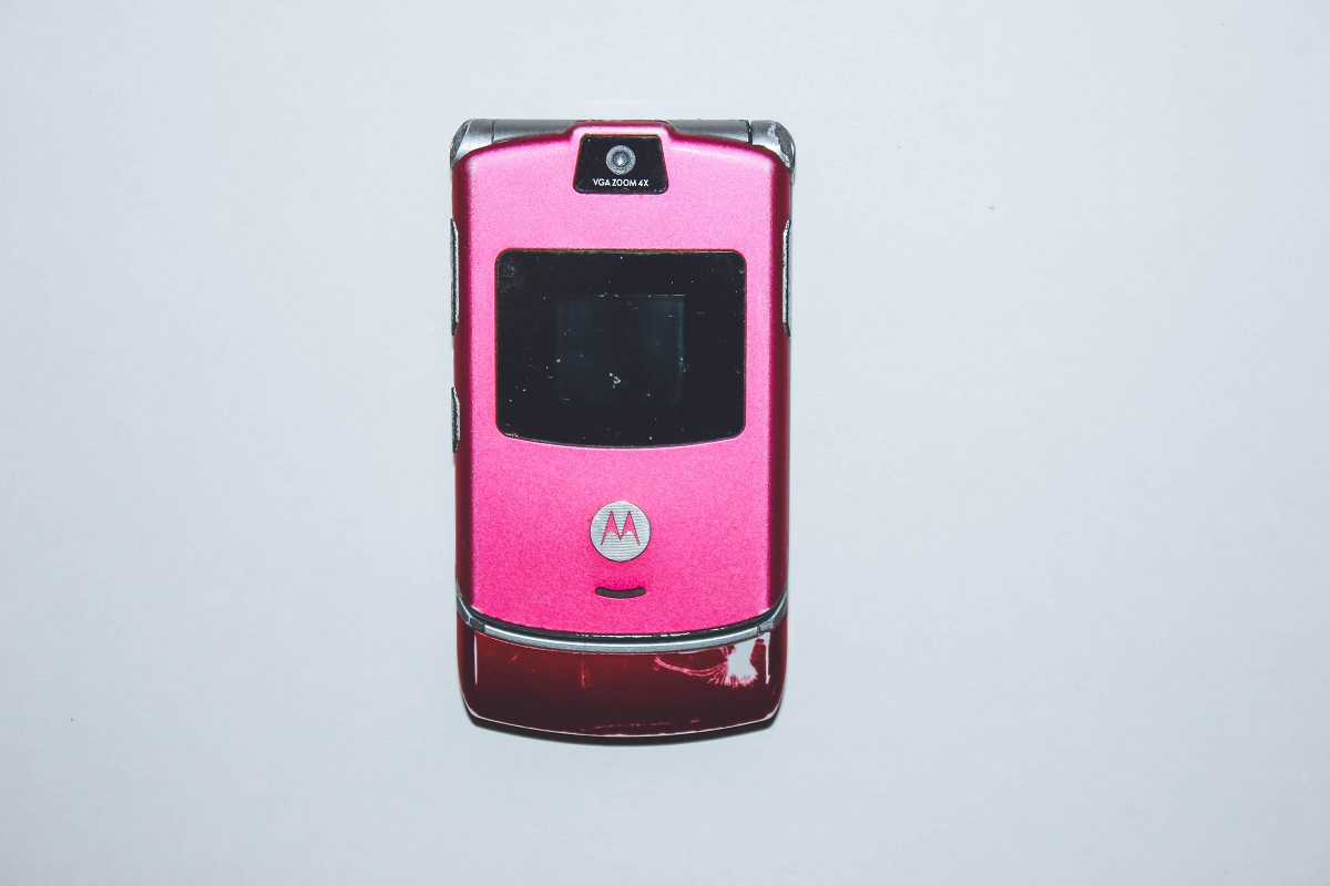Telefon Motorola RAZR pe roz, închis, pe un fundal gri. Nu se vede butonul de Internet Motorola RAZR