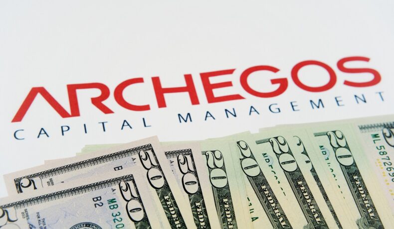 Imagine cu logo-ul Archegos Capital Management, pe fundal alb, cu bancnote de 20 de dolari în partea de jos a imaginii. Bill Hwang a fondat Archegos și a pierdut miliarde de dolari