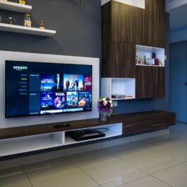 Imagine cu televizor Sony montat pe un perete, cu mobilă modernăși podea deschisă la culoare. Sony a dezvăluit primul televizor QD-OLED 4K, în cadrul CES 2022