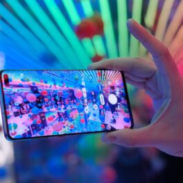 Samsung Galaxy S10, ținut în mână de un utilizator care face poză la culori și baloane. Samsung S22 e inclus în lista cu cele mai bune telefoane din 2022