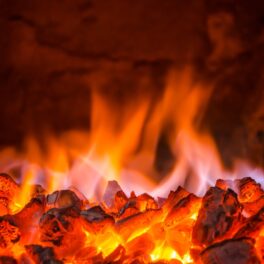 Foc de cărbuni într-un grătar din piatră, în nuanțe de roșu și portocaliu. Focul de 6.000 de ani din Australia e un foc de strat de cărbune