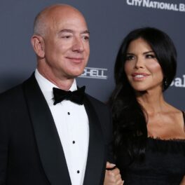 Jeff Bezos și Lauren Sanchez, la gala Baby2Baby, 2021, pe covorul roșu. El e îmbrăcat în costum negru și cămașă albă, ea poartă o rochie neagră, mulată. Jeff Bezos a petrecut alături de iubita lui