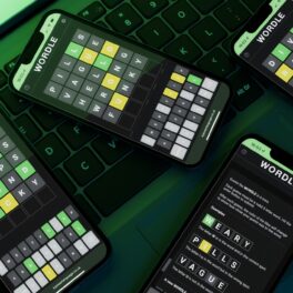 Mai multe telefoane pe care se vede jocul Wordle, pe o tastatură neagră, cu o lumină verde pe fundal. Există mai multe jocuri similare cu Wordle