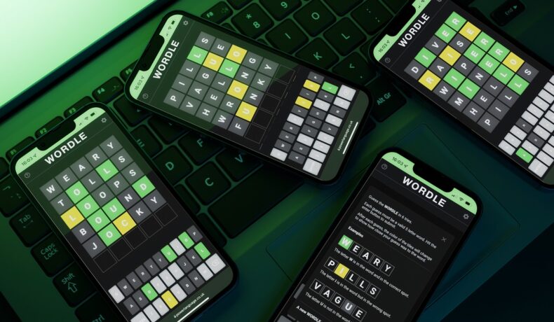 Mai multe telefoane pe care se vede jocul Wordle, pe o tastatură neagră, cu o lumină verde pe fundal. Există mai multe jocuri similare cu Wordle