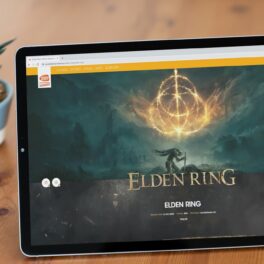 Imagine de pe pagina oficială a jocului Elden Ring pe o tabletă, pe o masă de lemn, cu o plantă pe fundal. Se numără printre numeroasele jocuri video din anul 2022