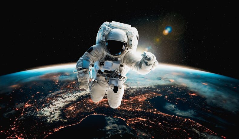 Astronaut în costum alb, care plutește în spațiu, cu Pământul pe fundal. Potrivit unui raport, misiunile NASA ar putea fi în pericol
