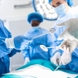 Chirurgi care operează în sala de operații, cu diferite unelte medicale, îmbrăcați în albastru. Recent, a fost realizat primul transplant al unei inimi de porc la om