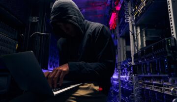 Hacker care lucrează pe un laptop, într-o cameră de circuite. Există numeroase secrete de securitate cibernetică ale hackerilor