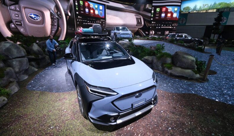 Subaru a dezvăluit mașina Solterra la un show auto din Los Angeles, în 2021. Mașina e albă, la salon