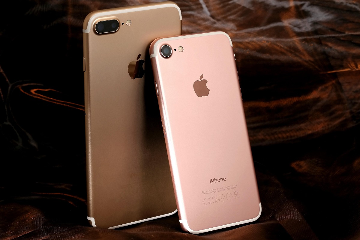 Telefoanele iPhone 7 și iPhone 7 Plus, pe roz, pe fundal maro și negru