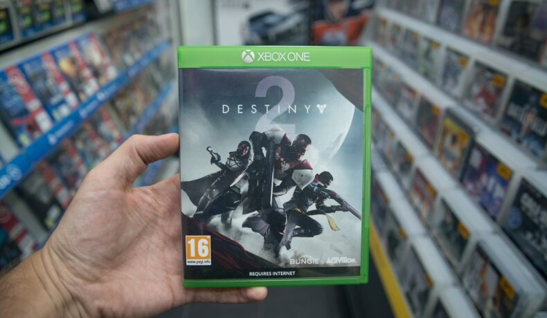 Carcasă cu jocul Destiny 2, ce include detaliul secret care a încântat fanii, ținută în mână de un utilizator din magazin