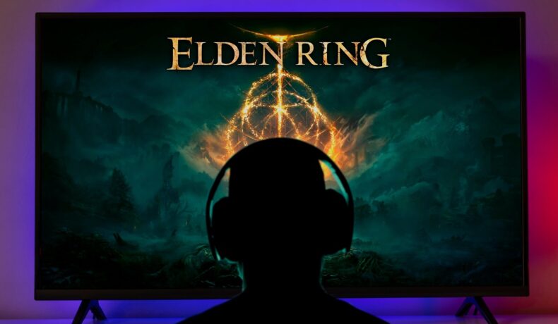 Jucător în umbră care stă în fața unui ecran pe care e Elden Ring, joc ce are probleme pe PC