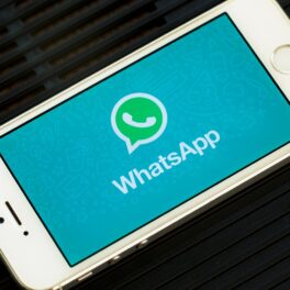 Aplicația WhatsApp pe ecranul unui telefon alb, pe fundal negru. Noile opțiuni care ajung pe WhatsApp pot încânta utilizatorii
