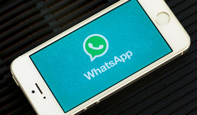 Aplicația WhatsApp pe ecranul unui telefon alb, pe fundal negru. Noile opțiuni care ajung pe WhatsApp pot încânta utilizatorii