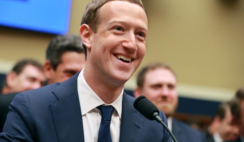 Mark Zuckerberg, în fața Congresului SUA, în aprilie 2018, îmbrăcat în costum, cu un microfon în fața lui. Mark va introduce o schimbare importantă pentru angajații lui