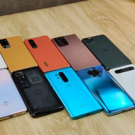 Două șinii de smartphone-uri, de diferite culori, pe un birou din lemn. Cel mai bine vândut telefon din 2021 e iPhone 12