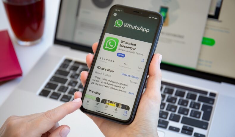 Aplicația WhatsApp pe ecranul unui telefon mobil și pe ecranul unui laptop. Acum poți folosi contul WhatsApp pe mai multe dispozitive